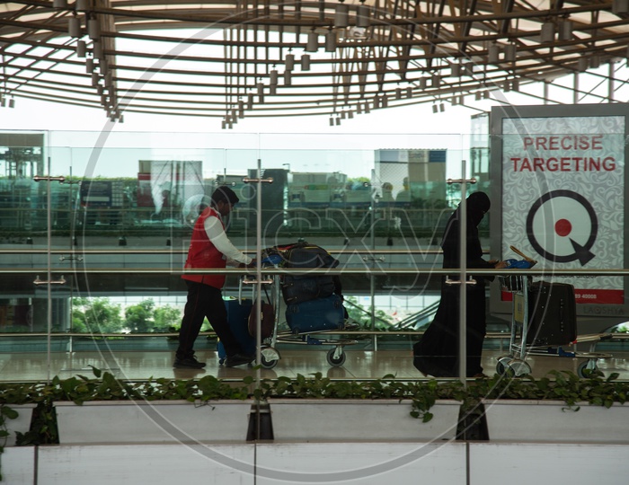 Passengers  with their baggage carried by Airport Potters at Rajiv Gandhi International Airport (HYD), Hyderabad