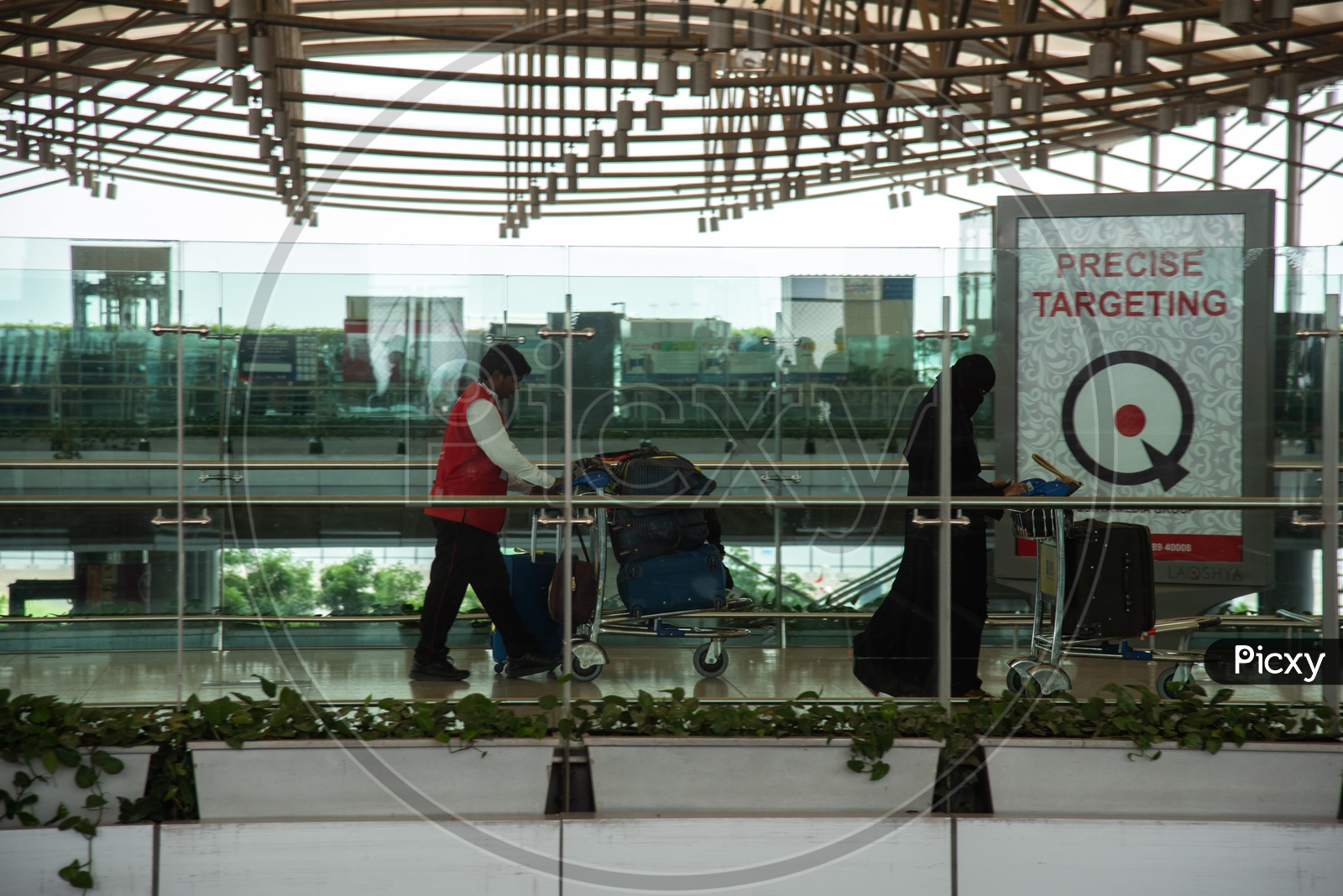 Passengers  with their baggage carried by Airport Potters at Rajiv Gandhi International Airport (HYD), Hyderabad