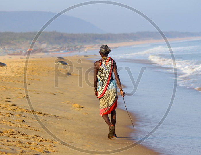 Old Woman walking in Beach