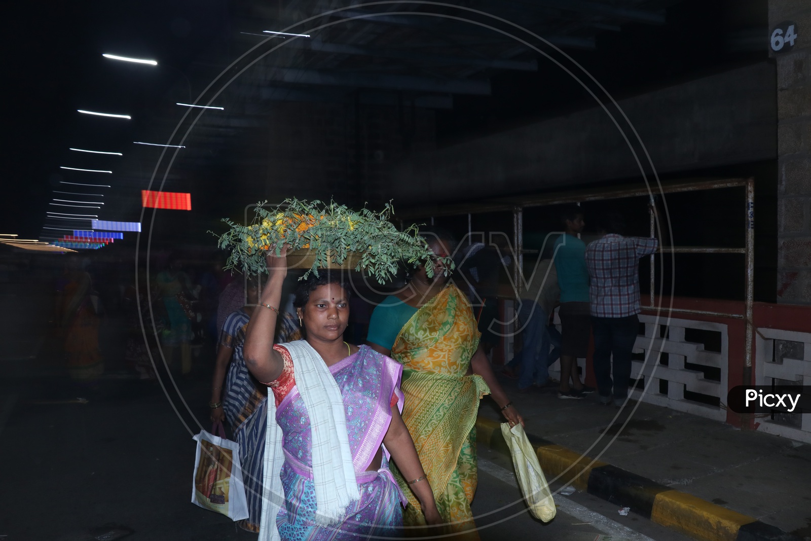 a woman carrying flowers on head(bathukamma) to offer goddess durga on  9th day of Navrathri's uring Dasara/Dussehra