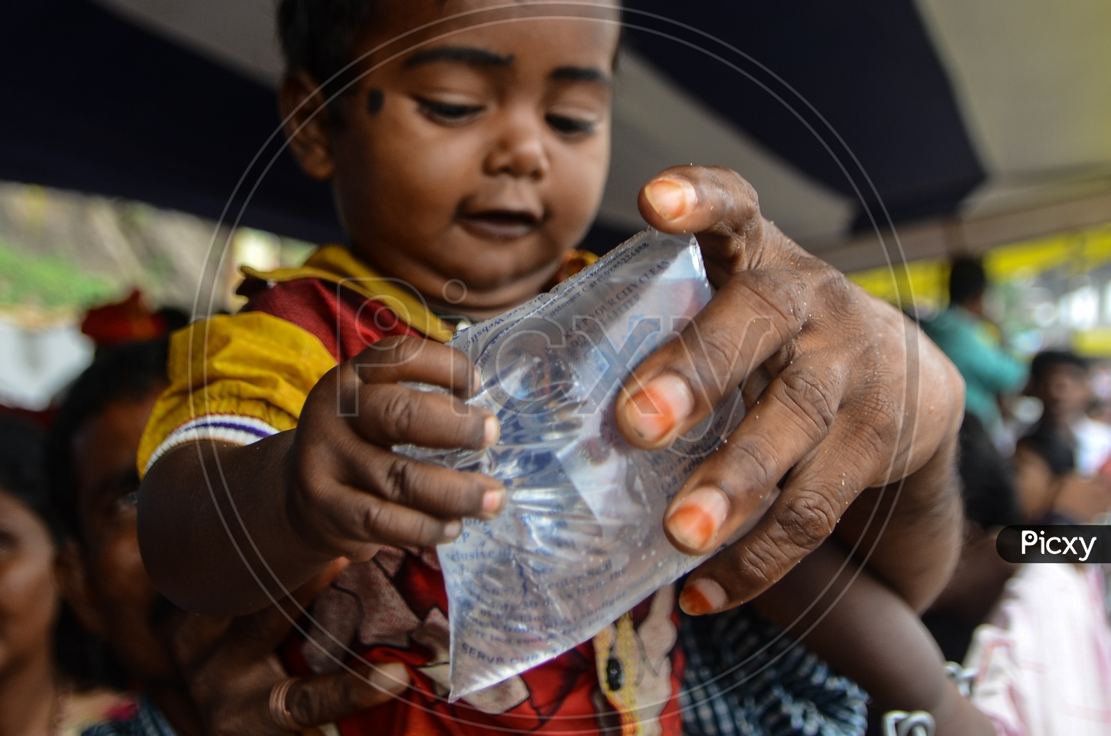 A boy takes a water packet