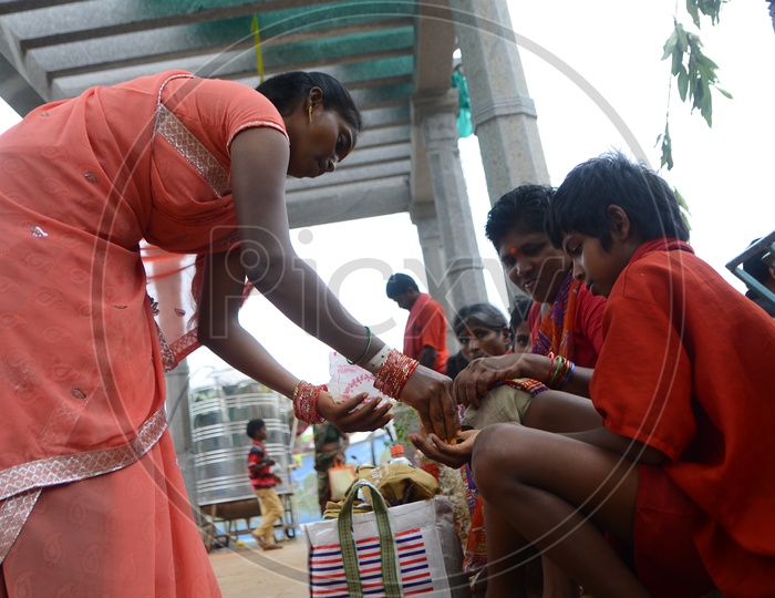 A woman distributes Prasadam(Offering) to devotees