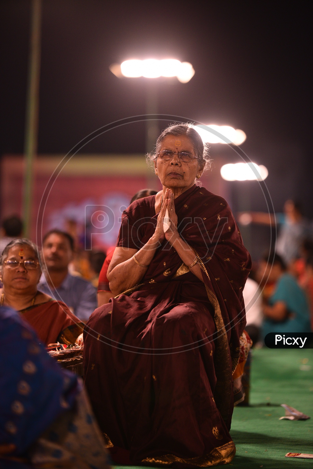 An elder hindu woman praying at Koti deepotsavam