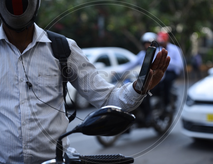 Man with Mobile phone in hand while on bike