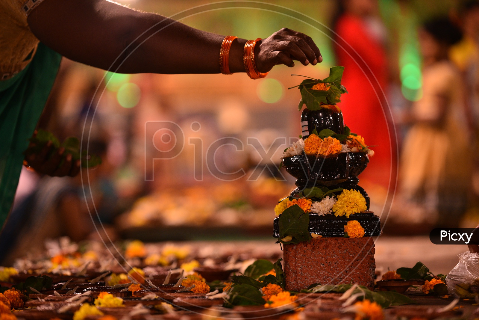 women decorate hindu god shiva idol(shiva linga)