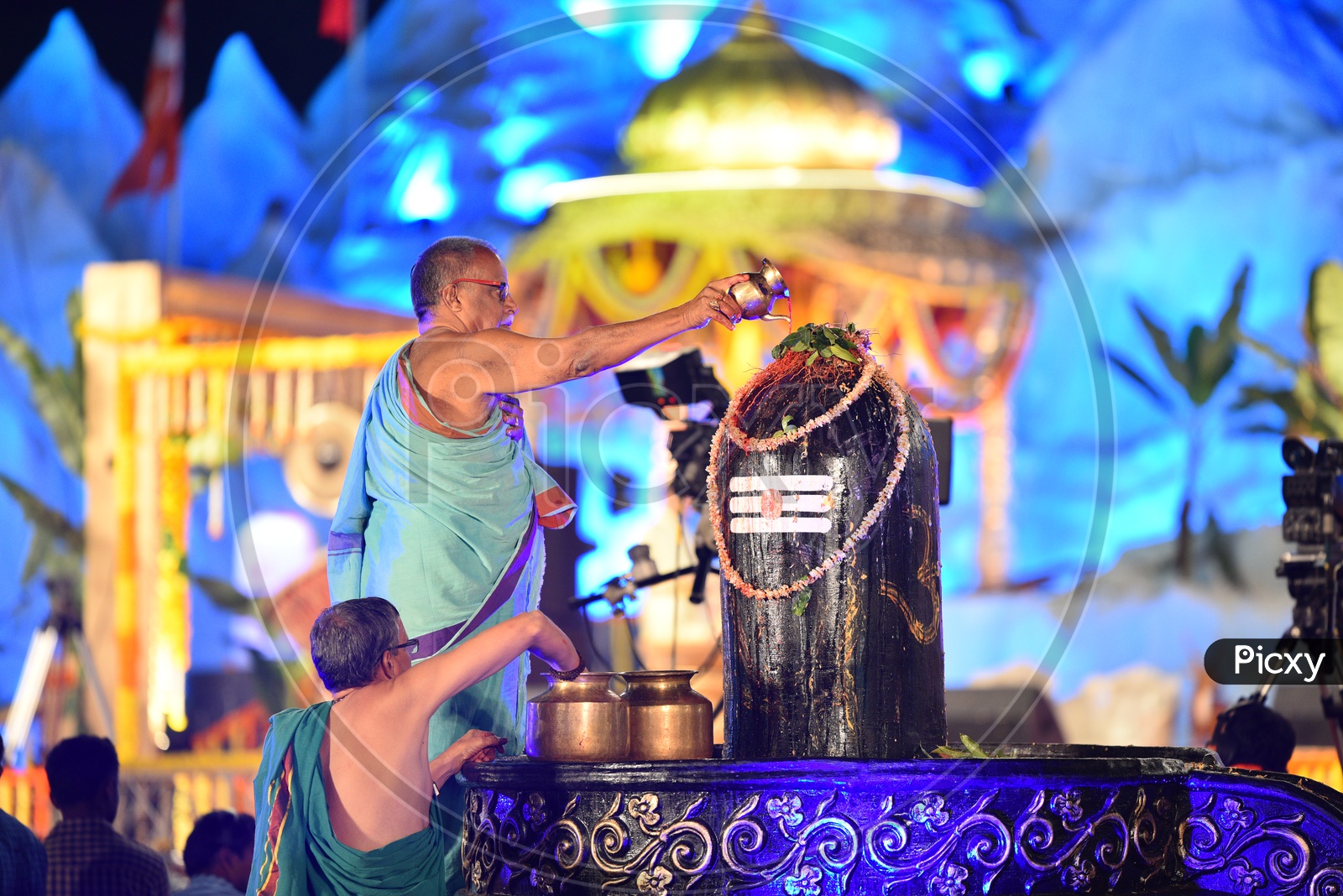 A priest/pujari performing rites to a shiva linga