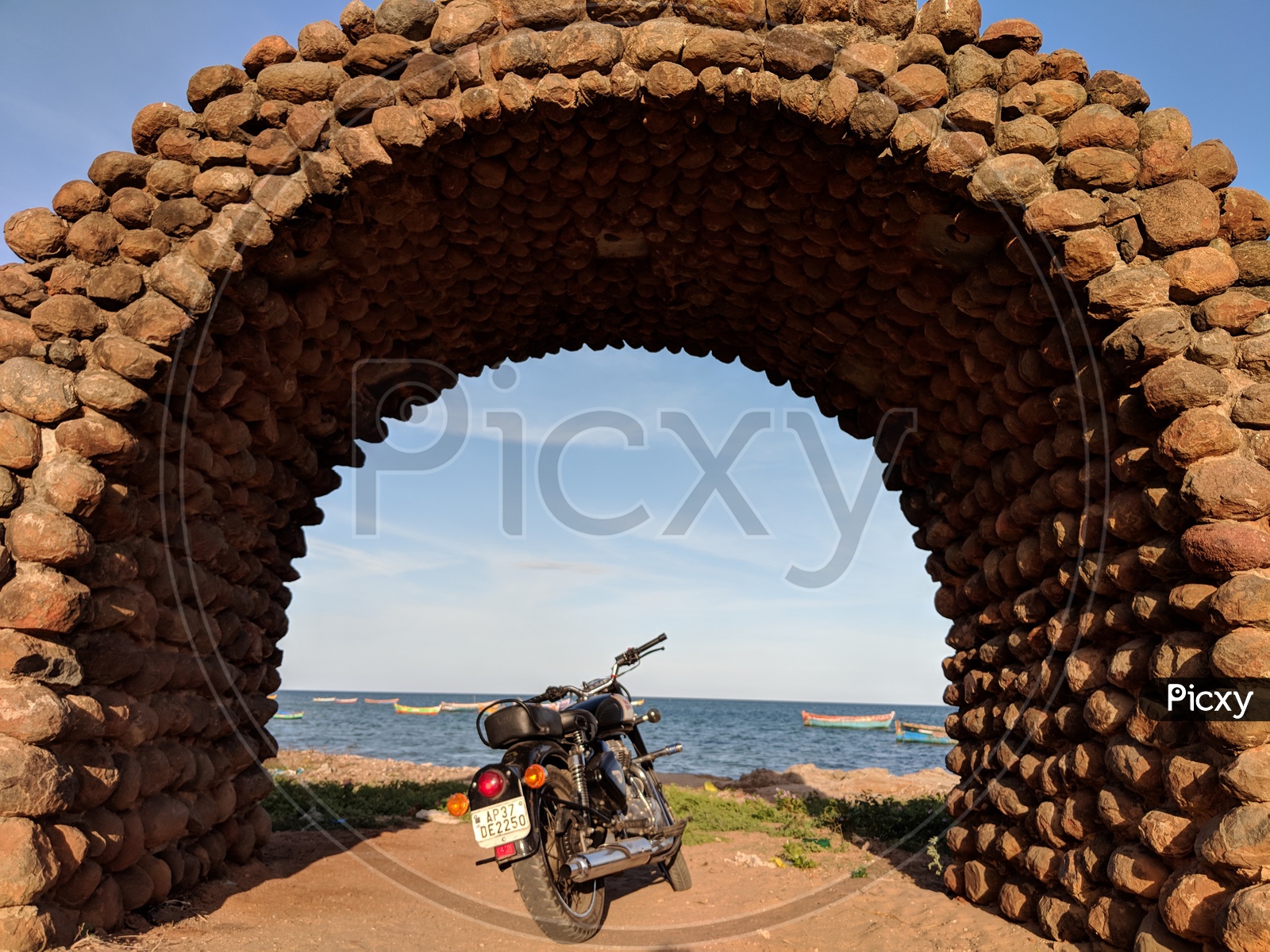 Royal Enfield Bike under a Stone Shade by the beach
