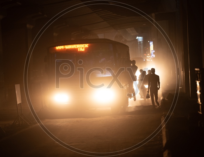 Vehicles/Pedestrians cross through a Dust/Smoke/Smog covered Krishna Nagar Metro rail Station as the Road has been demolished to lay new roads