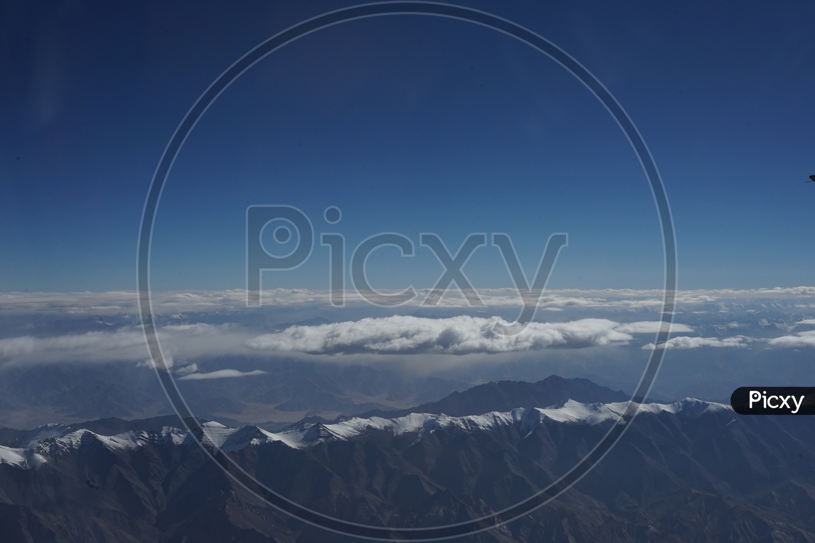Clouds above Snow capped Mountains of Himalayas