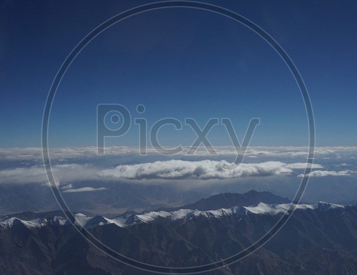 Clouds above Snow capped Mountains of Himalayas
