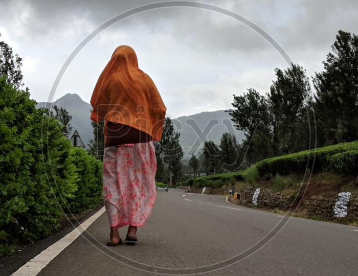Woman walking on road near Valaparai Tea Plantations