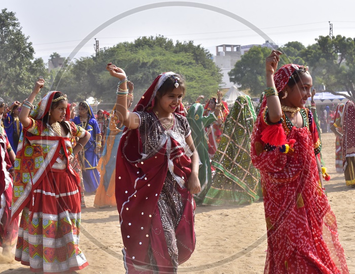 Women in Colorful dresses dancing at Pushkar Camel Fair