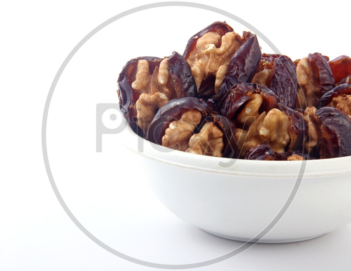 Walnut-Stuffed Dates in Bowl Isolated in White Background