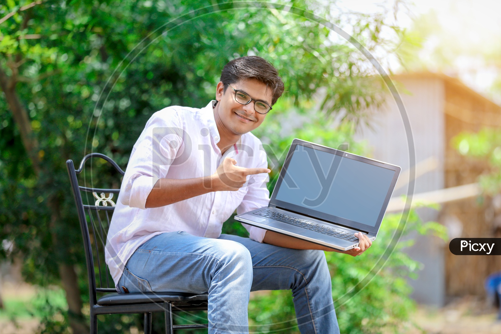 Indian College Student using Laptop with smiling face.