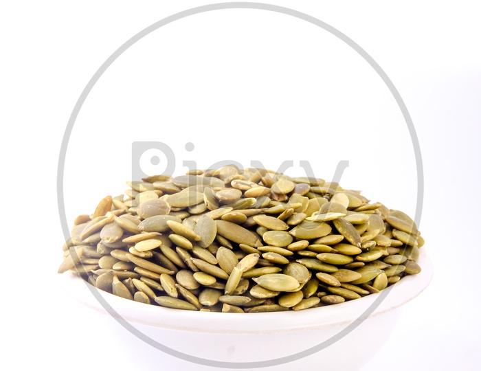 Pumkin Seeds in a Bowl on an Isolated White Background