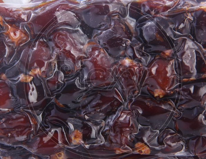 Dates Packed in a Tight Polyethylene Cover on a White Background