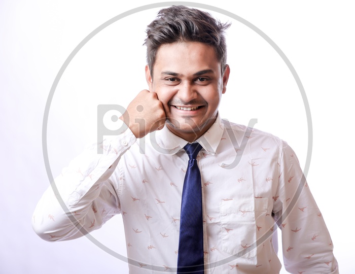 Portrait Of A Confident Youngman in Formalwear  With Expression and Punching his Fist to Face   With White  Background