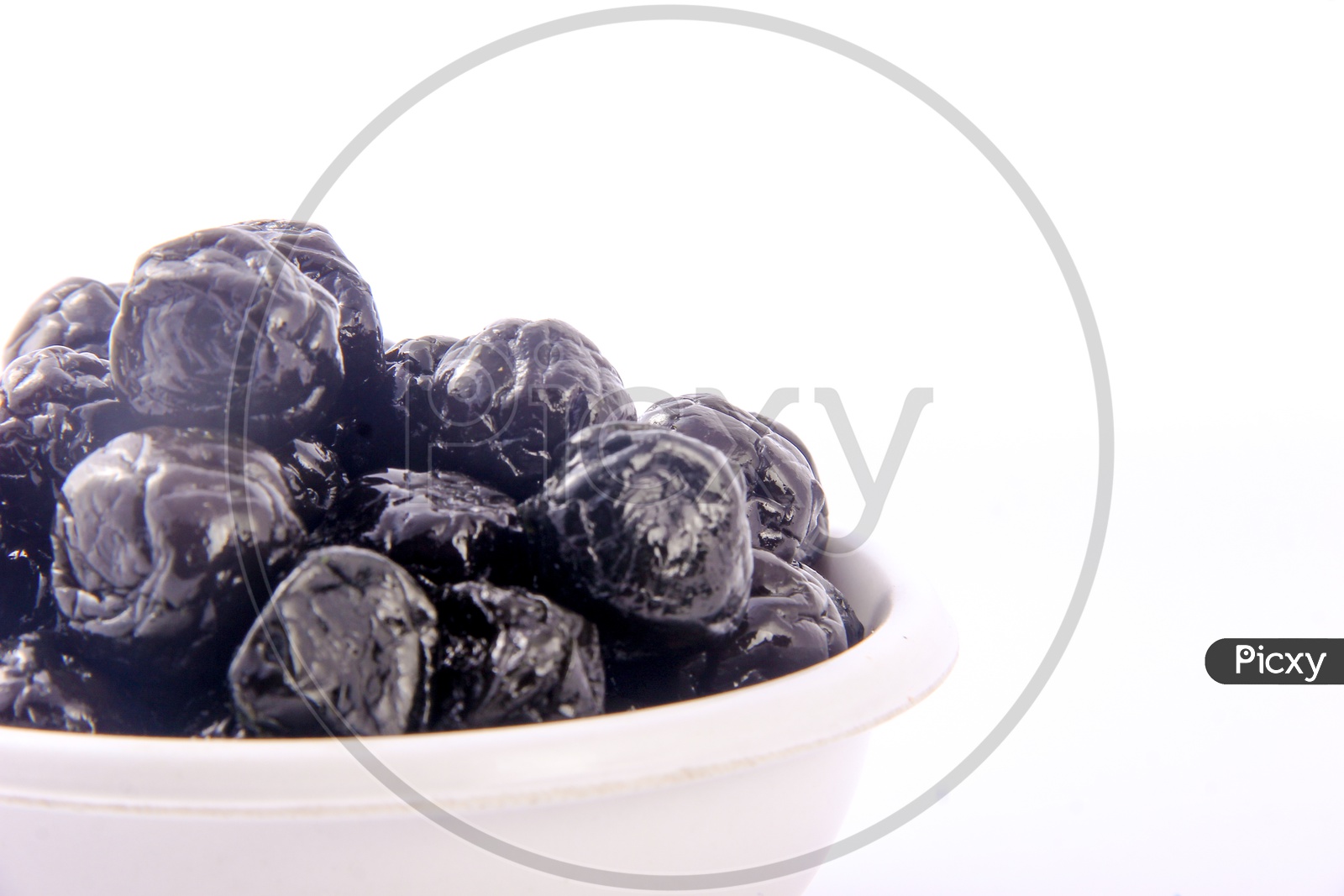 Dry Prunes / Plums In a Bowl On an Isolated White Background