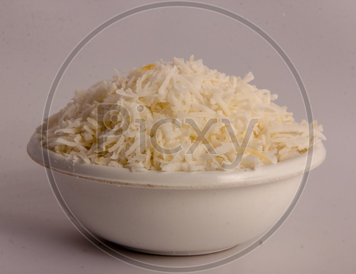 Dried Grated Coconut in a Bowl on an Isolated White Background