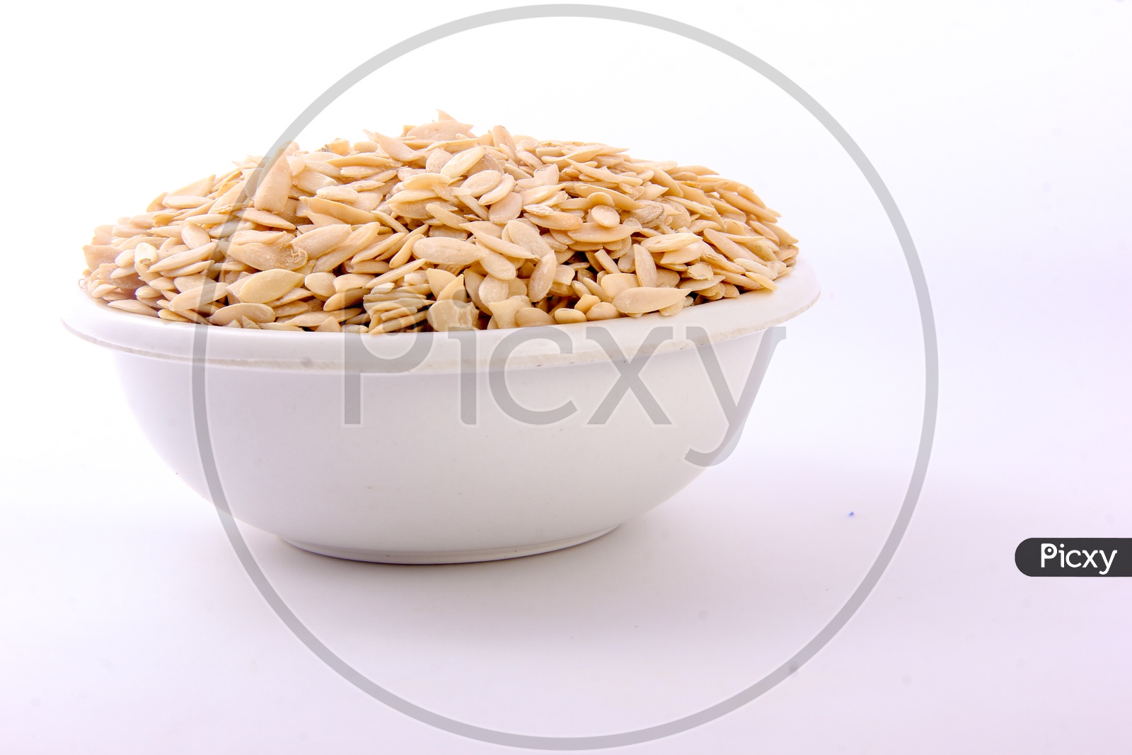 Dry Muskmelon Seeds in a Bowl on an Isolated White Background