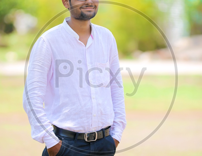 A Confident Young Indian man With His hands In Pockets and Smiling