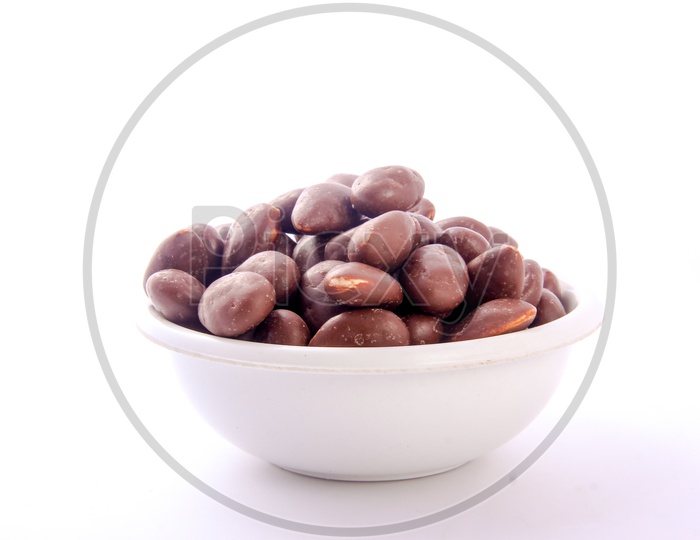Chocolate Coated Almonds in Bowl Isolated in White Background