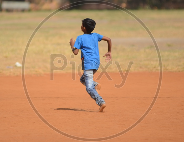 A boy runs on a play ground