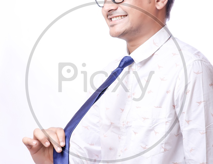 Portrait Of A Confident Youngman in Formalwear  With Expression and Holding His Tie   With White  Background