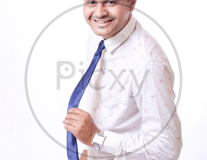 Portrait Of A Confident Youngman in Formalwear  With Expression and Holding His Tie   With White  Background