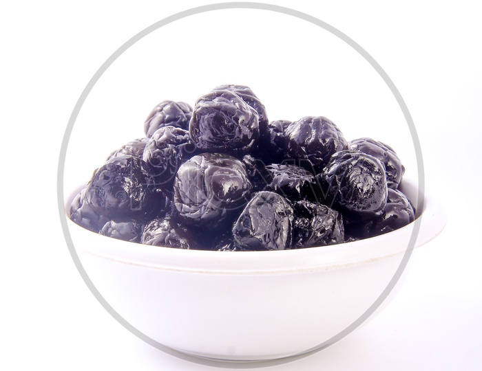 Dry Prunes  / Plums in a Bowl on an Isolated White Background