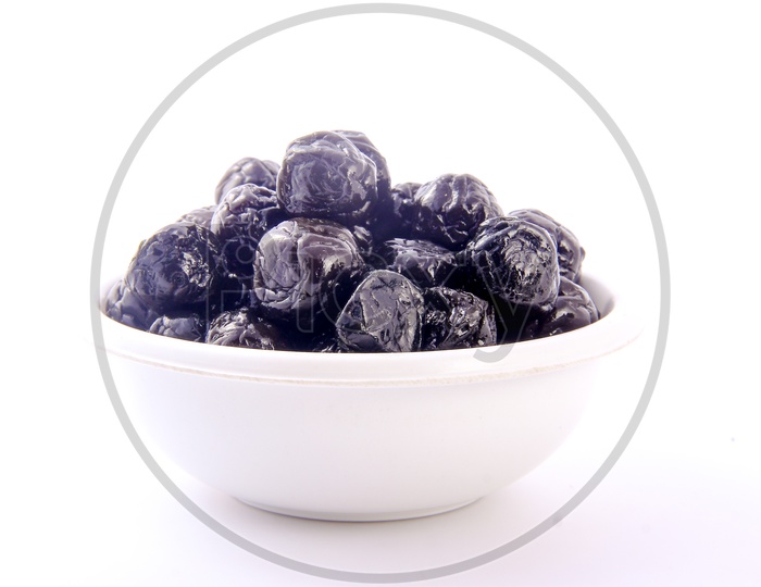 Dry Prunes / Plums In a Bowl On an Isolated White Background