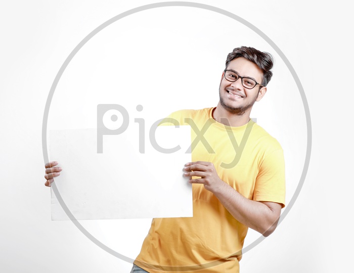 Young Indian Model Showing Blank Poster with white background and smiling face.