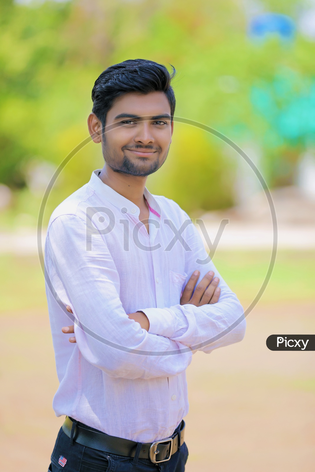 A Young Indian man Standing With a Folded Hands and confidently smiling