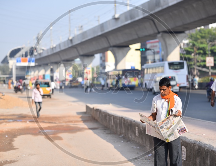 Man Reading Telugu News Paper on Road