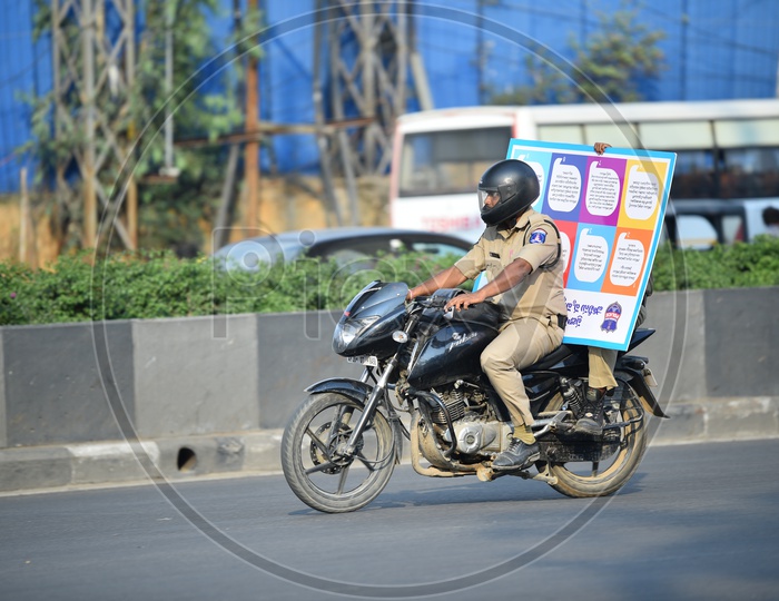 Policeman Riding with a Signage on Bike
