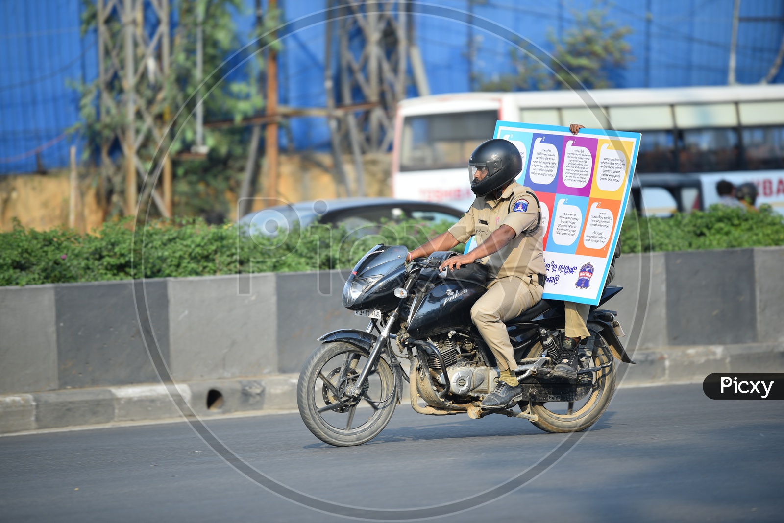 Policeman Riding with a Signage on Bike