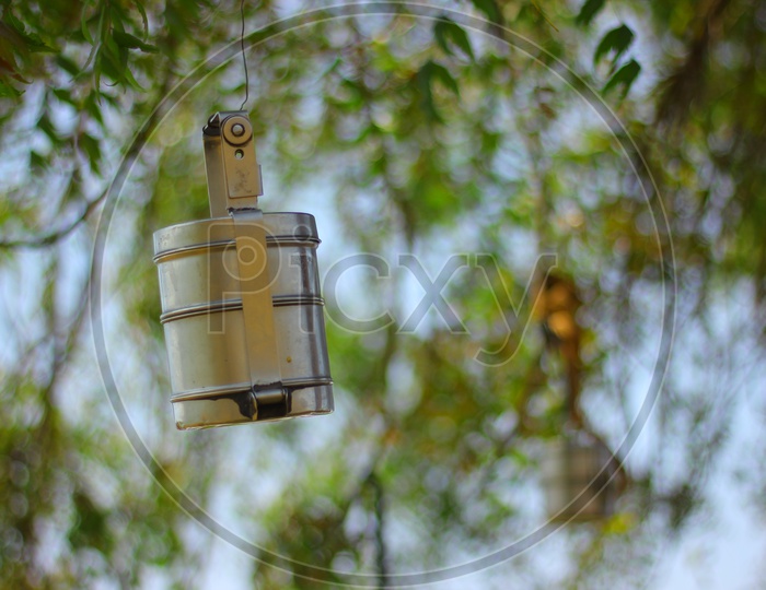 A Lunch Box / Steel Food  Carrier  hanged to tree by a Farmer in his Field
