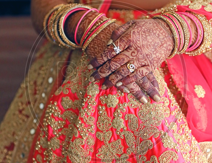 Grrom Sitting in a Chair in Indian Wedding Wearing Traditinal Lehanga Showing  Her Hands In Closeup