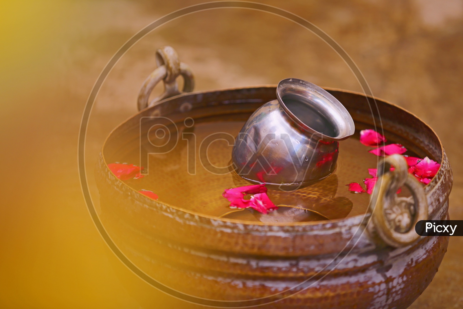 Water in Copper Tub with Rose petals which is Bath efore Wedding , Bridal Bath / Groom Bath in Traditional Hindu Wedding
