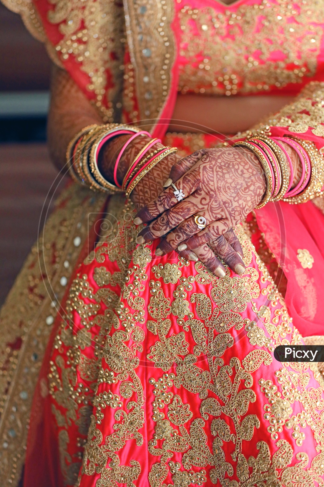 Grrom Sitting in a Chair in Indian Wedding Wearing Traditinal Lehanga Showing  Her Hands In Closeup