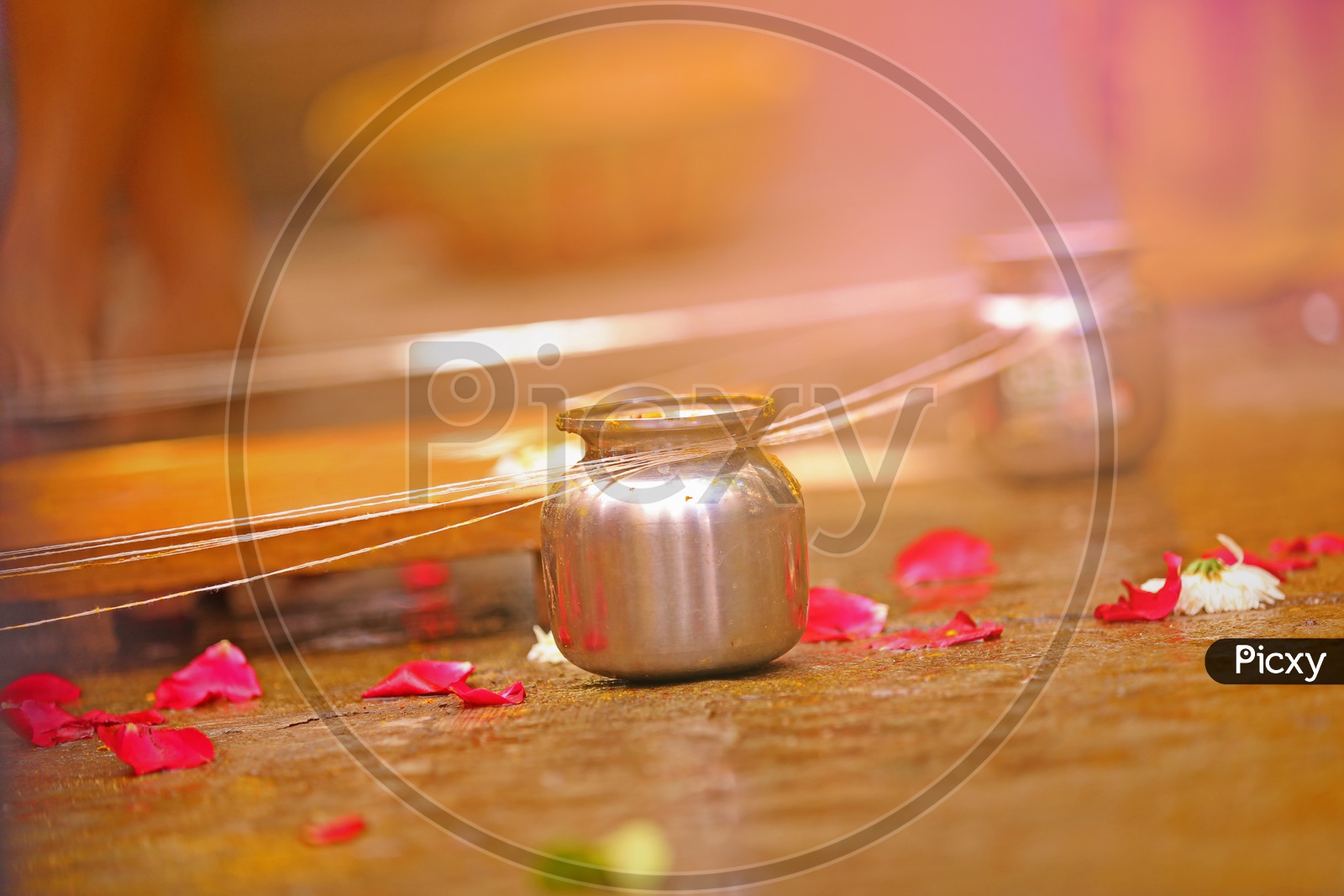 A Hindu Wedding Coustom Ritual Shots / A tumbler With Thread Tied and rose Petals Lying on Floor