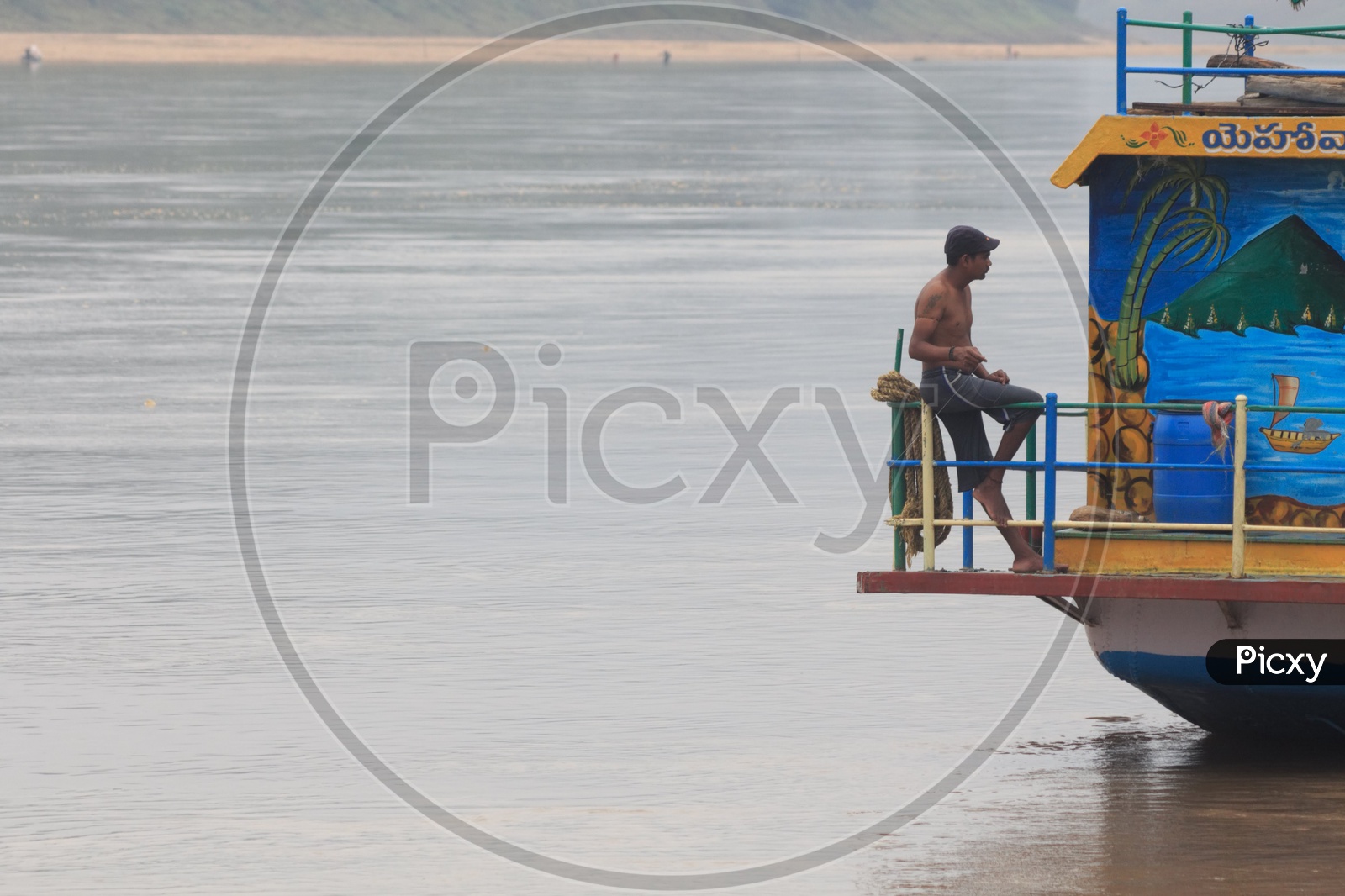 A man sitting on a boat sailing on river Godavari.