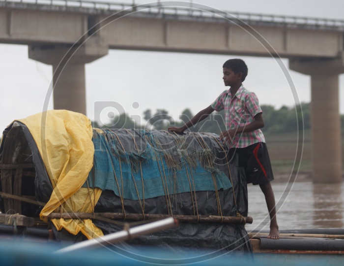 A Boy standing on the boat on river godavari.
