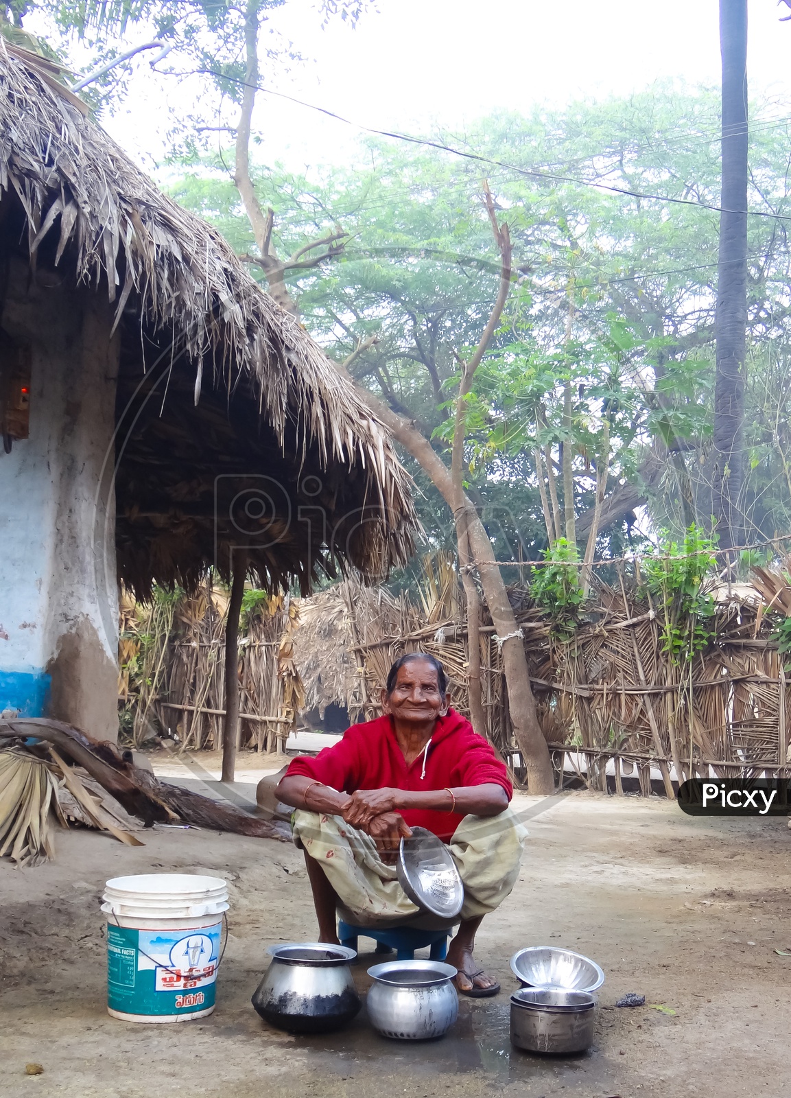 Image of Old Granny/Woman/Lady in a village doing dishes-TM763199-Picxy