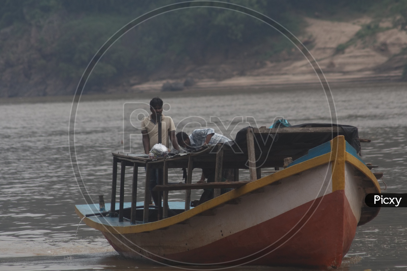 Two men standing in the boat parked at river godavari.