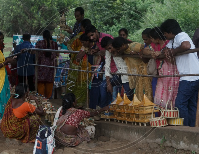 People purchasing wooden house toys on the bank of river godavari.