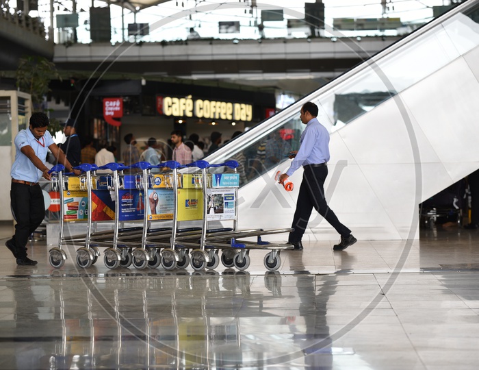 A Staff pushing the luggage trolleys in RGI airport.