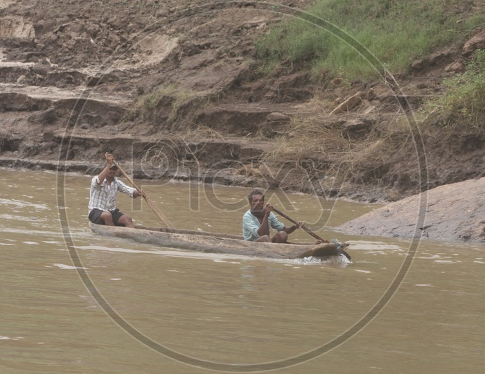 Two men Rowing a boat at river godavari.