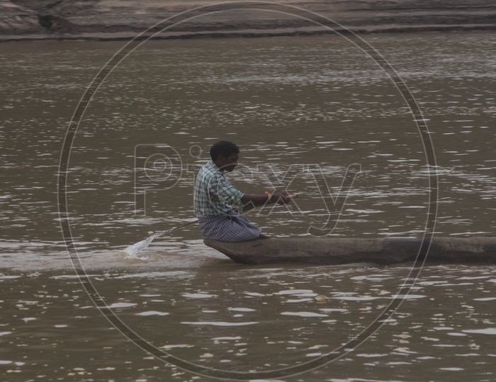 A Man rowing a boat on river Godavari.