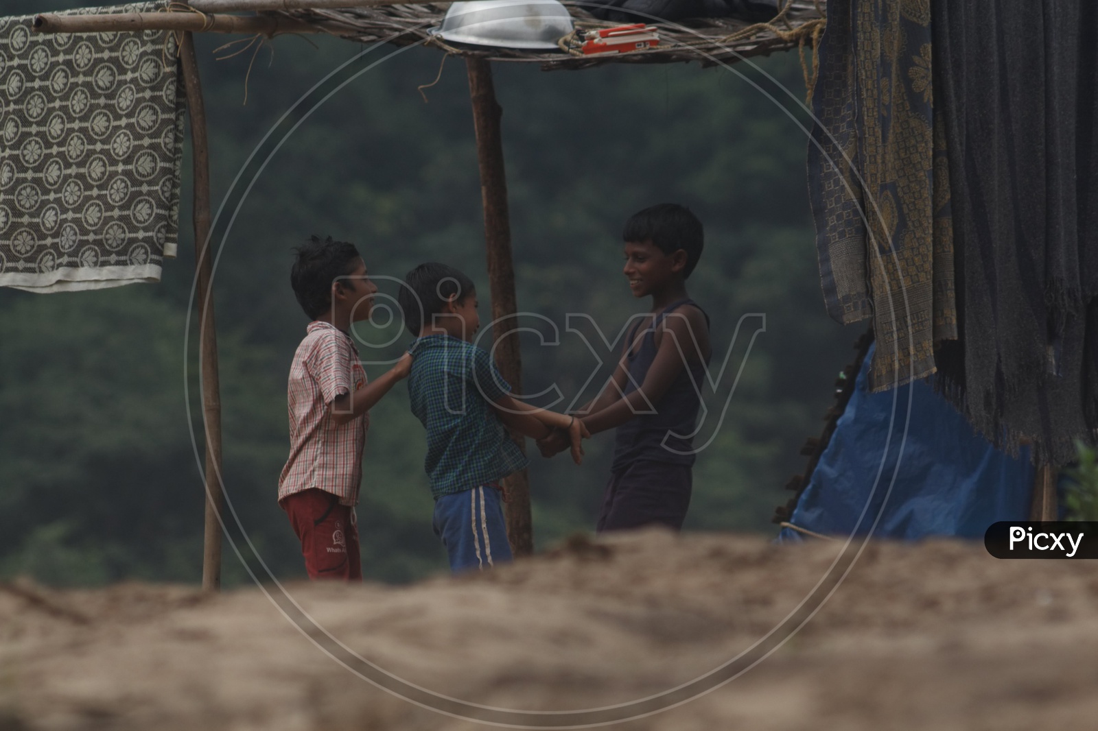 Three boys playing with each at the bank of river godavari.